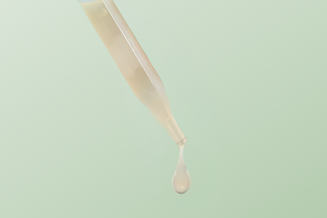 Dropper releasing a droplet of Sukina Apothecary's Magic Fruit Brightening Serum, showing its lightweight, silky texture designed to brighten, purify, and even skin tone.